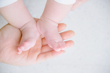 Newborn baby feet in mother's hand.