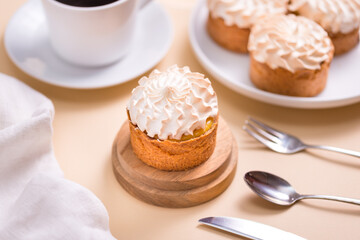 Sweet tart with cream and cup of coffee on beige table