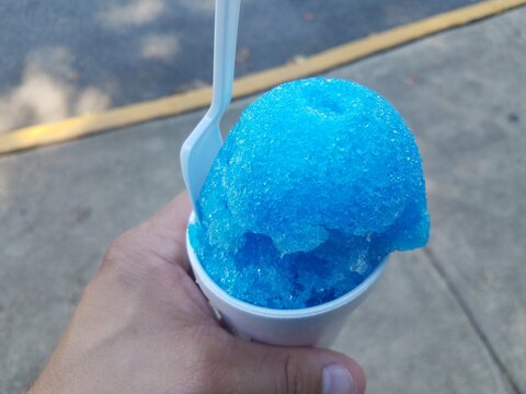 Hand Holding Blue Snow Cone In A Cup