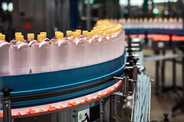 Bottling factory - Juice bottling line for processing and bottling lemon juice into bottles. Selective focus.