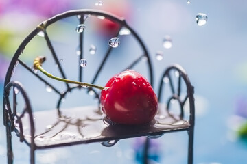 sweet cherry on a bench in the rain. spring card