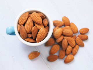 Almond seeds from blue glass isolated in white table.