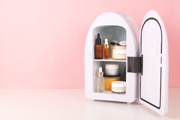 Mini fridge on pink background. Minimal composition. Copy space for your text.