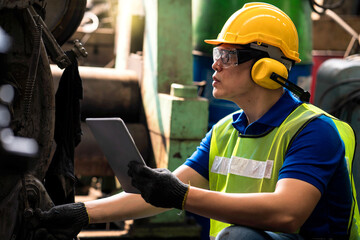 Staff or technicians are checking the operation of the old machine via the tablet.