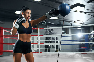 Sportswoman training in boxing gloves.
