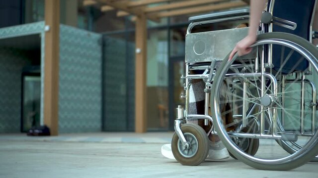 Young woman in a wheelchair. A girl rides in a wheelchair close-up hand. Special transport for the disabled.