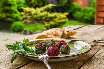 Georgian traditional snack Pkhali with vegetables and nuts. Combined with walnuts, garlic, and herbs. Served on ceramic plate with lavash and basil, wooden background.