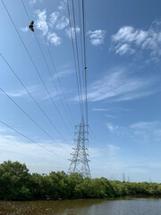 Electric tower, lake, and beautiful blue sky at madh marve road Mumbai.