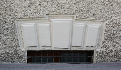 A basement window with a metal barrier