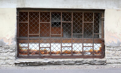 A basement window with a metal barrier