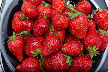 Ripe red strawberries on a plate, vitamins
