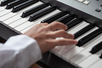 Fototapeta na wymiar Closeup hand man playing piano. keys in focus.
