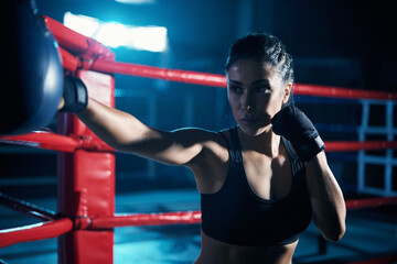 Female fighter training in boxing gloves.