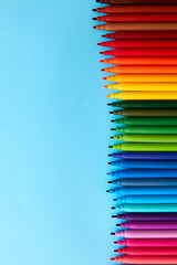 Row of colored pencils with copy space on blue background