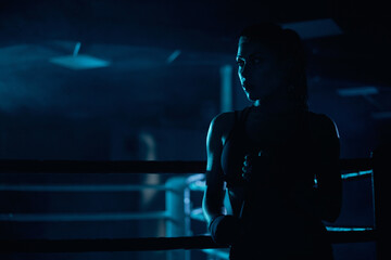 Female boxer binding the bandage on hand.