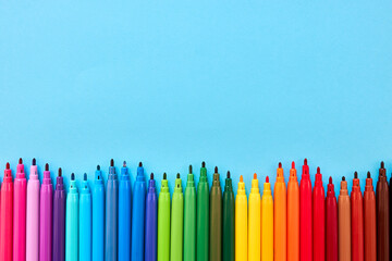Row of colored pencils with copy space on blue background