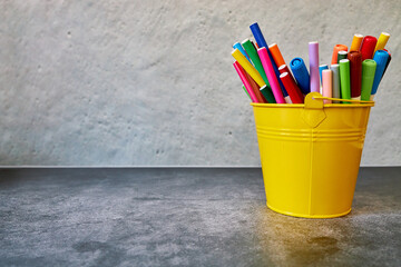 Yellow glass filled with colored pencils. Copy space and background