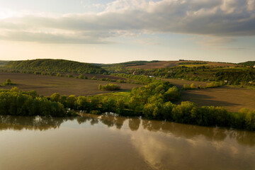 Fototapeta na wymiar Aerial view of bright river flowing through green meadows in spring.