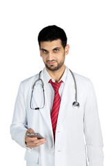 Fototapeta premium Handsome doctor using a mobile phone in the studio