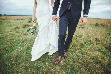 bride and groom walking in the field