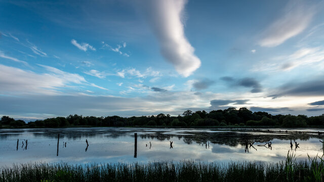 View over Arcot Pond, Cramlington, Northumberland, England, UK. In blue evening light with clouds overhead.