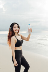 Beautiful woman drinking water after exercising