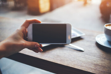  happy hipster girl making photo with cell telephone for a chat with friends while sitting in cafe