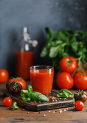 Tomato juice and fresh tomato with basil on rustic background