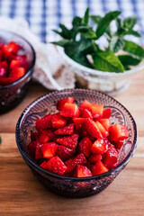 Salade de fruits frais - Fraises au sucre et menthe fraiche dans un bol