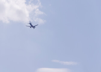 plane flying away into the distance against a blue sky