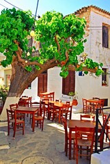 Greece, Skiathos island, tables and chairs outside of a local traditional tavern in the town of...
