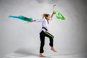 beautiful girl in white does kung fu training poses with battle axes