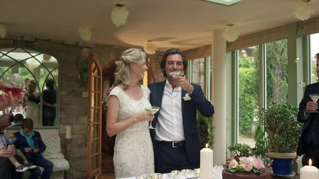 WS TU Bride and groom drinking champagne at wedding reception / Dinton, Wiltshire, United Kingdom