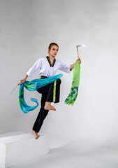 beautiful girl in white does kung fu training poses with battle axes
