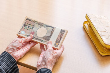 100万円を持つ手　給付金イメージ　シニア　老人