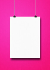 White poster hanging on a pink wall with clips