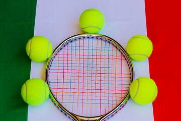 Italian tennis /Tennis racket in metal with colored ropes and yellow tennis balls with the italian flag in the background