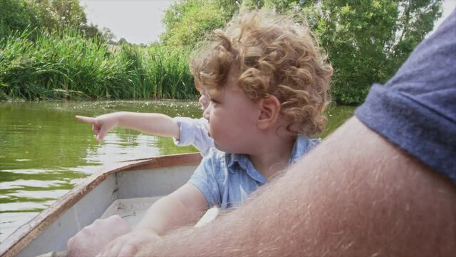 CU POV Father and sons (2-3) rowing boat at lake / Dinton, Wiltshire, United Kingdom