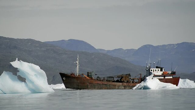 WS TS Rusty boat sailing among icebergs close to Narsaq / South Greenland, Greenland