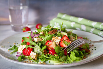 Feta cheese strawberry cucumber rocket (arugula) salad with pecan nuts - healthy vegetarian food