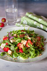 Feta cheese strawberry cucumber rocket (arugula) salad with pecan nuts - healthy vegetarian food