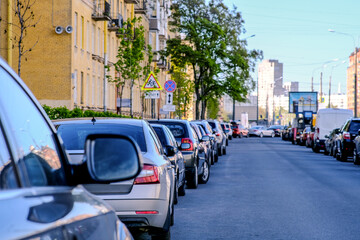 Background, blur, out of focus, bokeh. Morning soft sunlight, cars parked on the streets of the city.