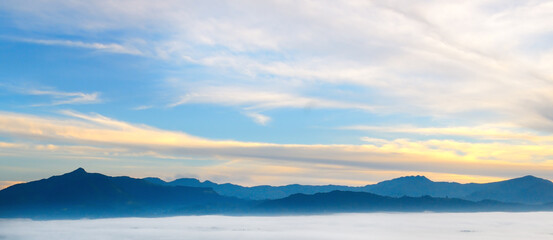 Fototapeta na wymiar Sunrise in mountains, fog and cloud mountain valley landscape. Wide photo.