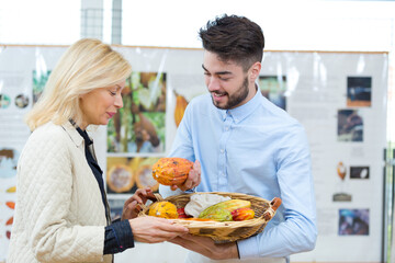 customer and saleswoman choosing fresh fruits in grocery store
