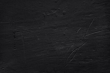 Black wall background. Black plastered wall with scratches, bumps and dents. Monochrome photo.