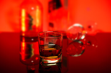 whisky glass with the blurred bottle backdrop on the red ambient background
