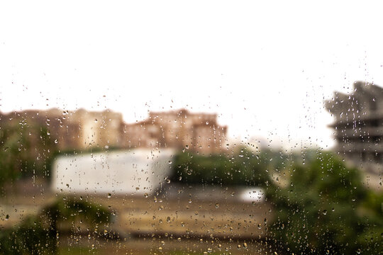 Textura de la lluvia sobre un cristal mojado con gotas de agua con vistas de la ciudad de Valencia de fondo