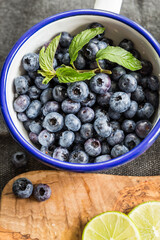 Top view of fresh blueberries and mint leaves on metal ladle.