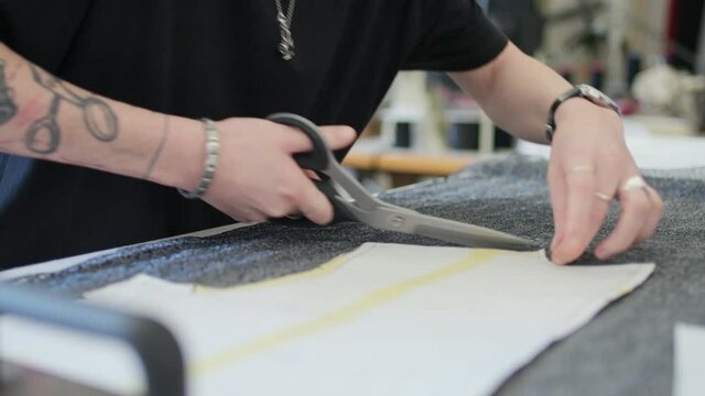 CU Woman cutting sewing pattern in workshop / Milan, Italy