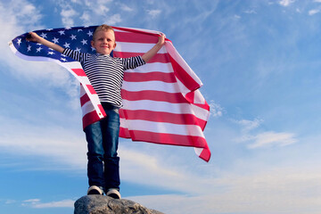 4k. Blonde boy waving national USA flag outdoors over blue sky at summer - american flag, country, patriotism, independence day 4th july